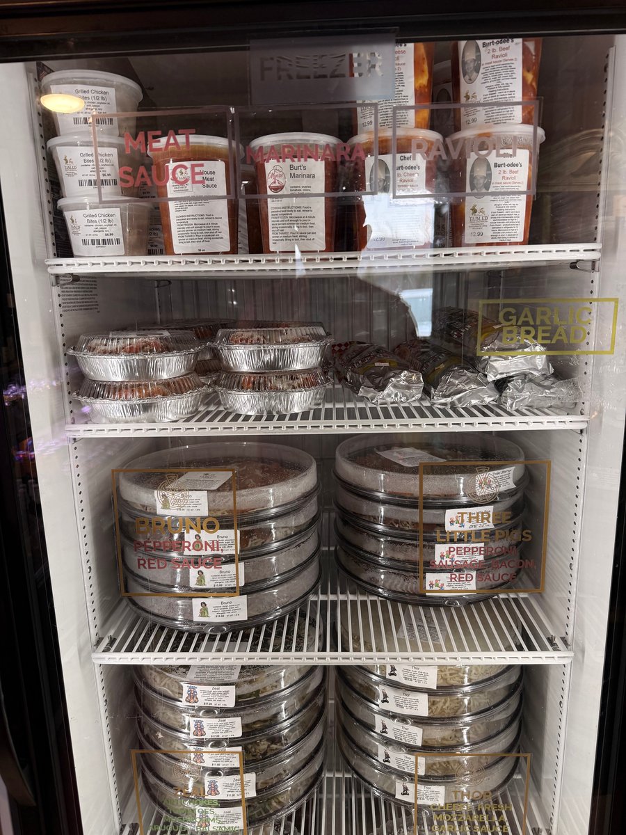 Freezer stocked with take and bake pizzas, sauces, and ravioli